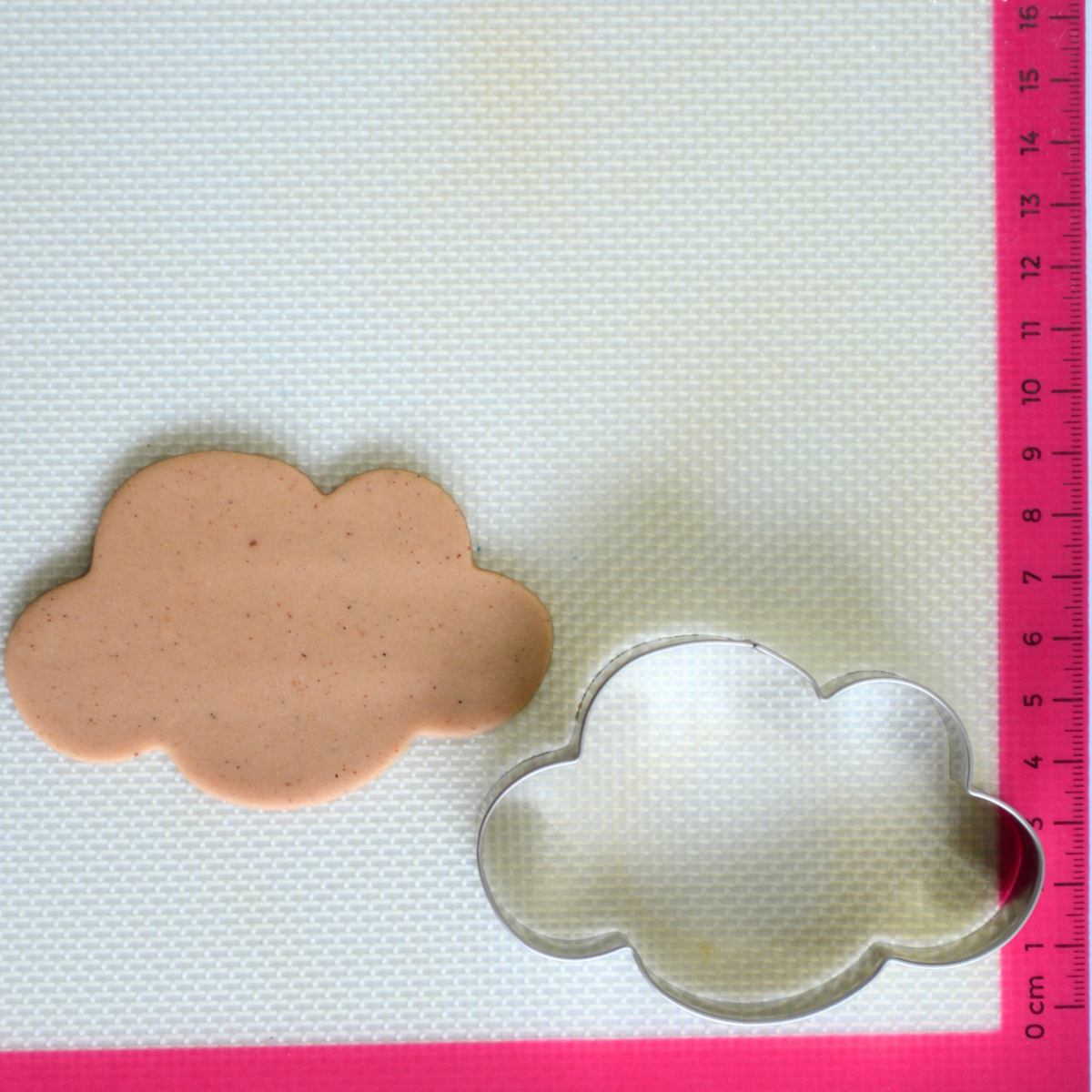 Cookie cutter cloud shaped with cookie dough cutout