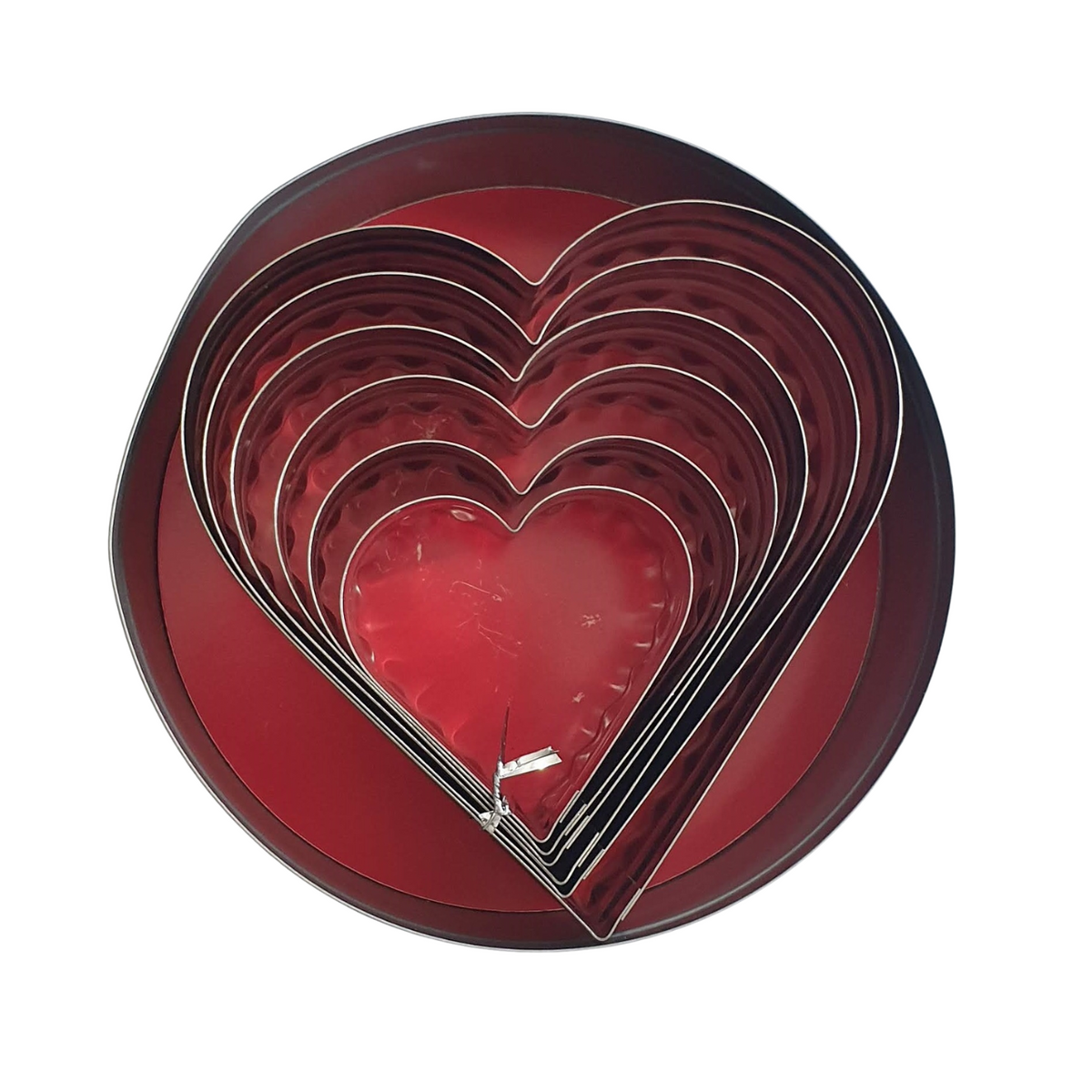 Set of 6 heart cookie cutters showing straight edges inside storage tin.  Heart cookie cutters with fluted edges on one side and straight edges on the other.