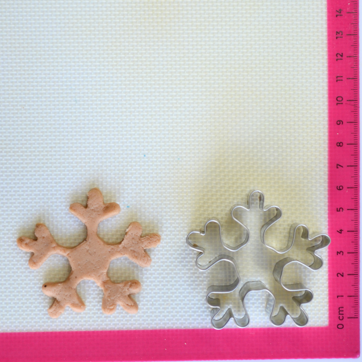 Snowflake cookie cutter with cookie dough cutout