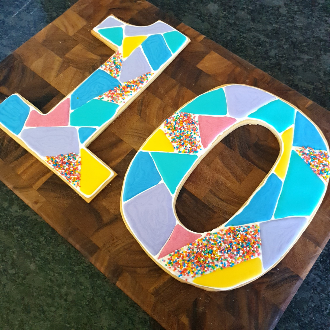 A large number 10 cookie deocrated in royal icing in lots of different colours.  The cookies were cut out using the cookie cake creators kit baking templates.